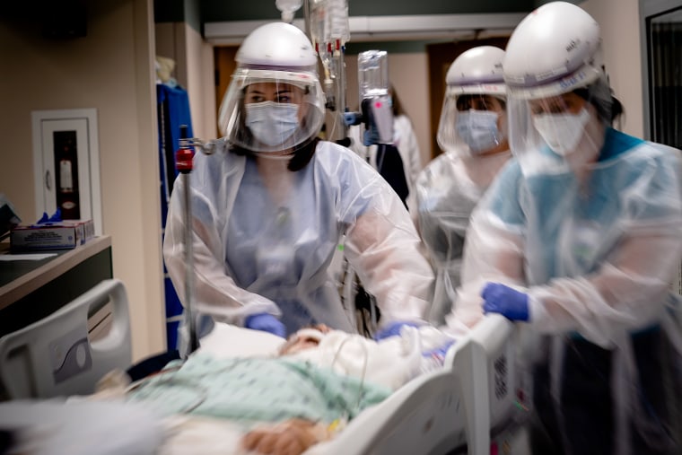 Image: Health care workers transport a patient on a ventilator, with complications due to Covid-19, for a scan at Baxter Regional Medical Center in Mountain Home, Ark., on July 8, 2021.