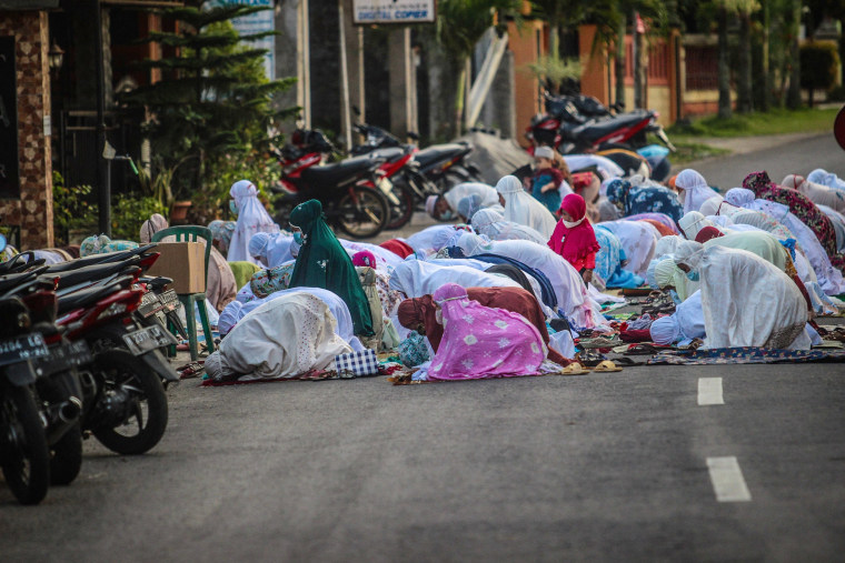 Image: Muslims gather on the road to pray outside a mosque to mark Eid in Central Java on Tuesday.