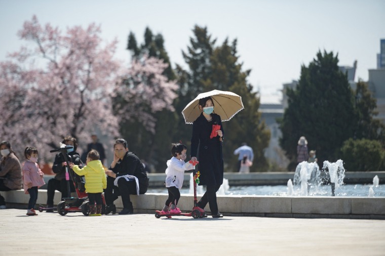 Image: A woman and child walk before a fountain in a park next to the Grand People's Study House in Pyongyang, North Korea.