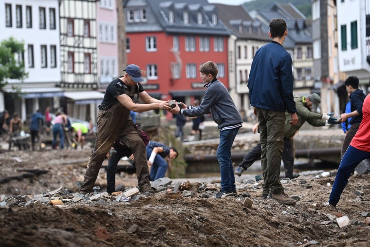 Image: People collect debris in the pedestrian area of Bad Muenstereifel, western Germany,