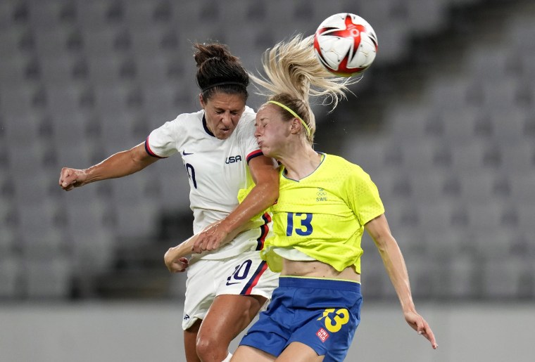 Image: United States' Carli Lloyd, left, and Sweden's Amanda Ilestedt, right, go for a header during a women's soccer match at the 2020 Summer Olympics