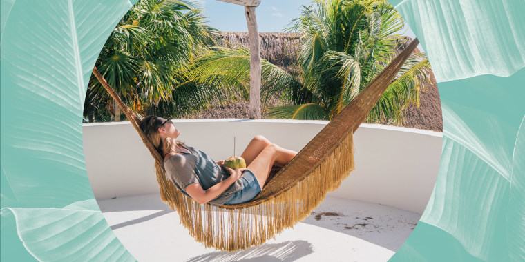 Woman relaxing in a Hammock, looking at the view, holding a coconut