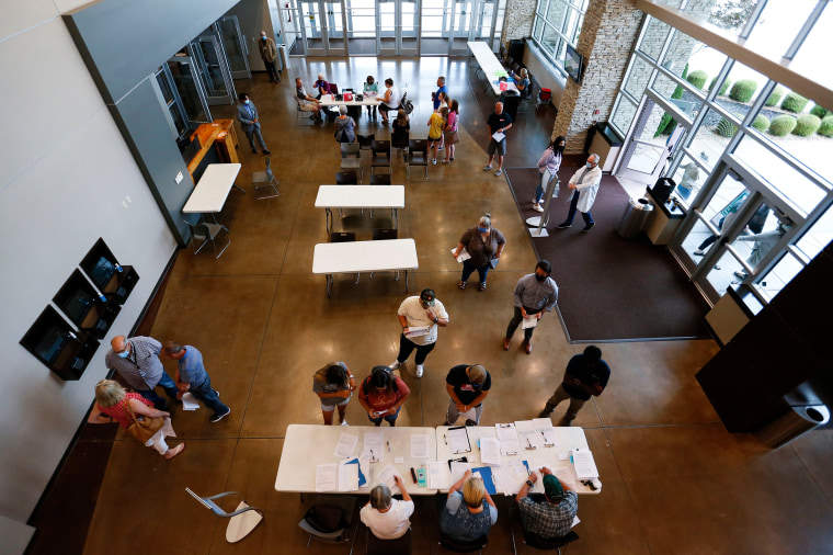 Image: People line up to receive Covid-19 vaccines at the James River Church West Campus in Springfield, Mo. during a vaccine clinic put on by Jordan Valley Community Health Center on July 12, 2021.