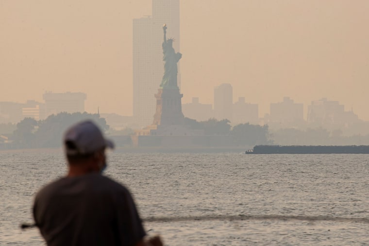 Image: The Statue of Liberty is seen through a cover of wildfire smoke in New York Harbor as seen from Brooklyn, New York