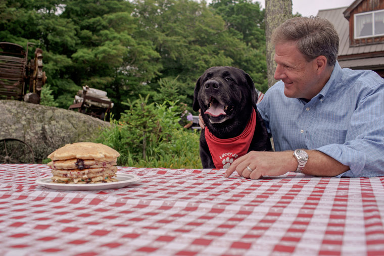 Sununu poses with "Lucky Jr.," a mascot for a local auto repair shop.