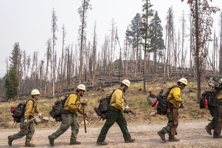 Firefighters from New Mexico walk toward the northwest edge of the Bootleg Fire while working to build a containment line on July 23, 2021, near Paisley, Ore.