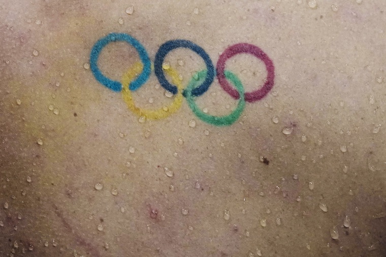 Water droplets fall down the back over a Olympics rings tattoo of Townley Haas, of the United States, swims at the 2020 Summer Olympics, Sunday, July 25, 2021, in Tokyo, Japan. 