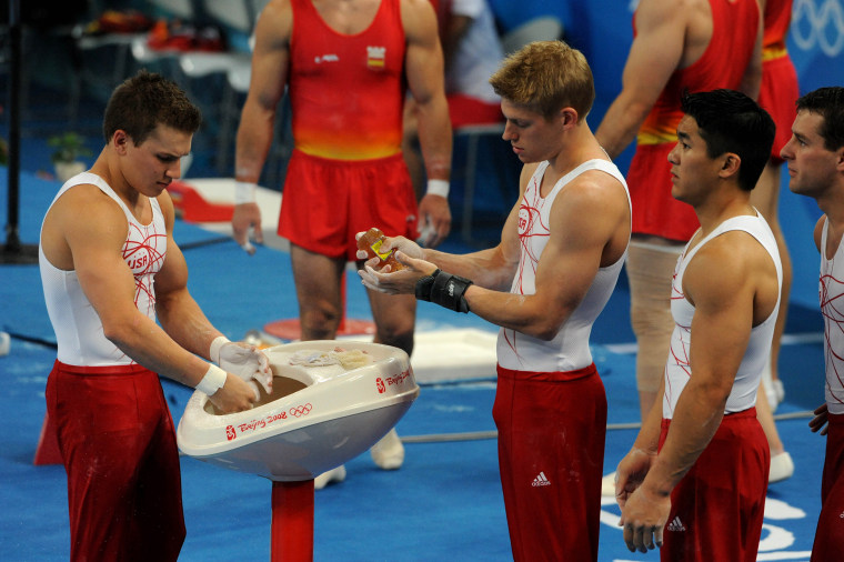 (HR) ABOVE: The Men's gymnastic team uses not only chalk but real honey on their hands prior to training on the parallel bars. They are from left to right Jonathan Horton, Justin Sprign, Kevin Tan and Joey Hagerty. The United States men's gymnastics team