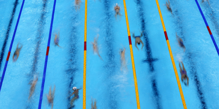 Swimmers warm up before competition at the 2020 Summer Olympics on Sunday, July 25, in Tokyo.