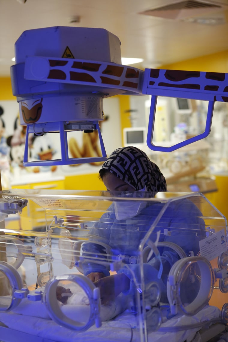 A nurse takes care of one of the nine babies protected in an incubator at a private clinic in Morocco; it was the first-ever birth of nonuplets who all survived.