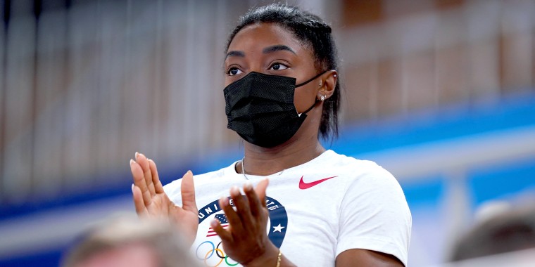 Simone Biles watches from the stands.