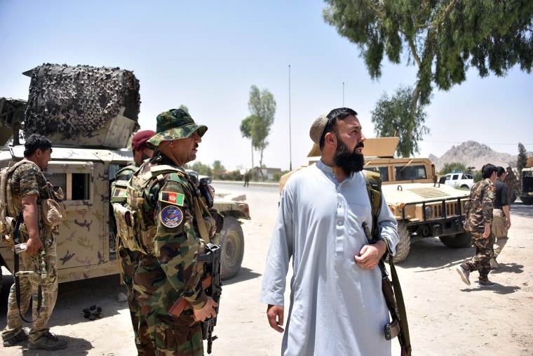 Image: Afghan security personnel stand guard along the road amid ongoing fight between Afghan security forces and Taliban fighters in Kandahar on July 9, 2021.