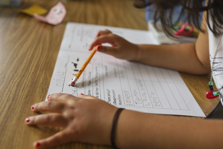 A child works on a kindergarten writing exercise during a dual-language summer program at Lot Whitcomb Elementary School in Milwaukie, Ore