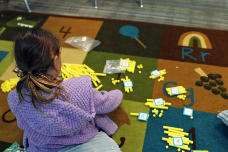 A rising first grader creates numbers using "ones" and "10s" cubes and blocks during an independent activity.