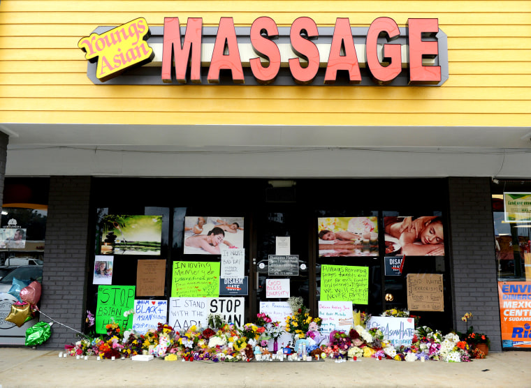 Image: Flowers, candles and signs lie at a makeshift memorial outside Youngs Asian Massage following the deadly shootings in Acworth, Ga., on March 19, 2021.