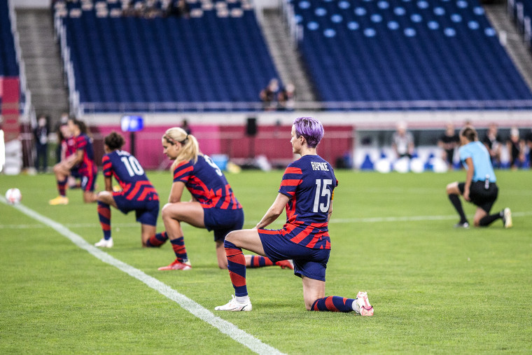 Megan Rapinoe and the United States team take a knee, along with the referee, before kick off during the USA V New Zealand group G match at Saitama Stadium at the Tokyo Summer Olympic Games on July 24, 2021 in Tokyo.