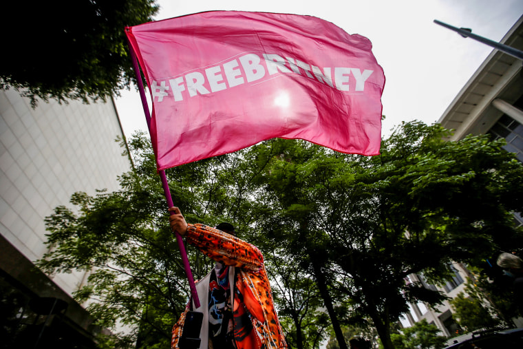 Image: A person waves a flag in support of pop star Britney Spears on the day of a conservatorship case hearing at Stanley Mosk Courthouse in Los Angeles on July 26, 2021.