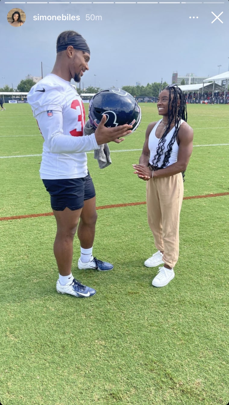 Photo of Simone Biles and her boyfriend in a green field