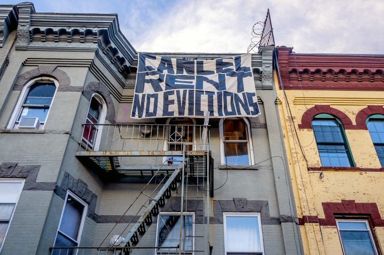 A "Cancel Rent No Evictions" banner hangs on an apartment building in Bushwick, N.Y., in July 2020