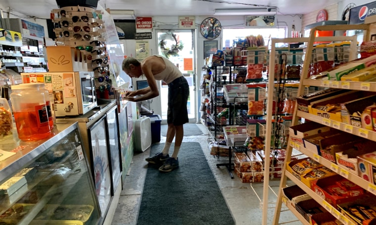 A customer pays for a purchase in the Palomino Deli and Mini Mart in Beatty, Ore., on Saturday. The store, the only one for miles in either direction on Highway 140, is a meeting place for locals.