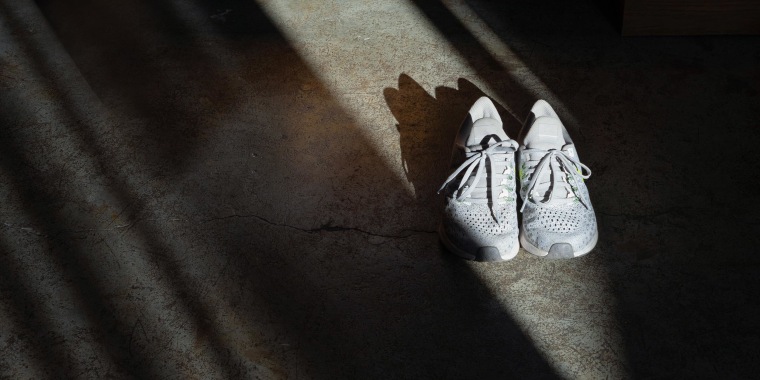 White running shoes on concrete floor in dark room