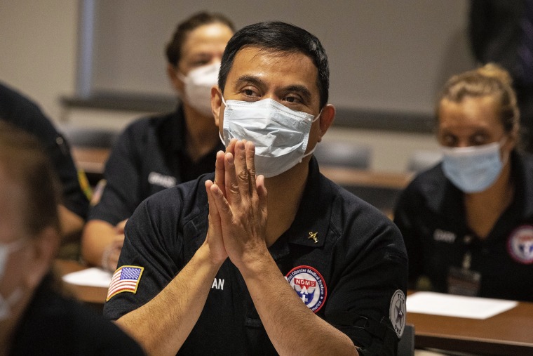 After his hands were blessed by a priest, Matthew Tran, a pharmacist, prays with nearly three dozen other healthcare workers from around the country who arrived to help supplement the staff at Our Lady of the Lake Regional Medical Center in Baton Rouge, L