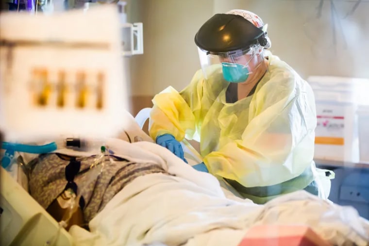 Image: Allison Moore, medical ICU nurse, helps a COVID-19 patient at the University of Mississippi Medical Center.