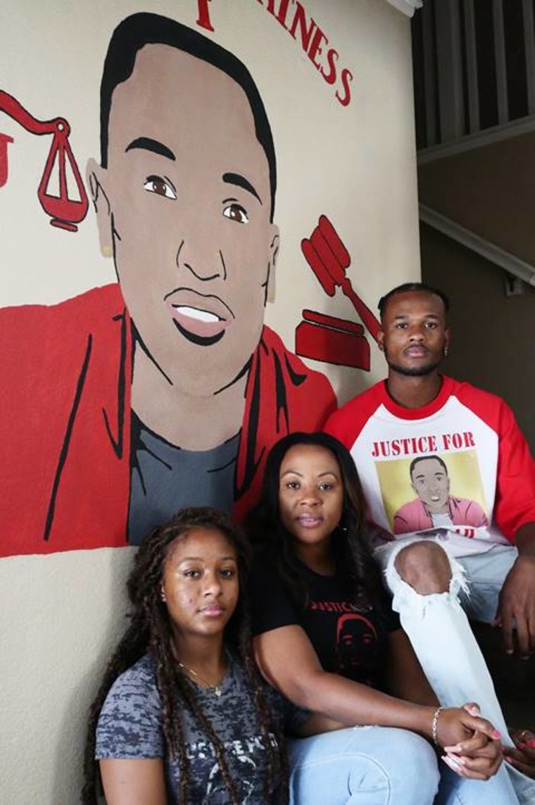 Charmaine Lawson with her daughter Chloe, left, and son Anthony, right, beneath a mural of Josiah in their home in Perris, California.