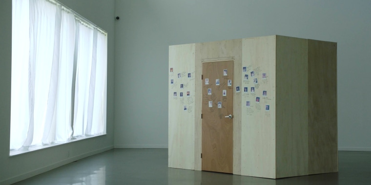 Image: A wooden box with photos on it in a room with a window.