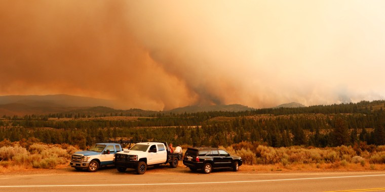 People watch as the Tamarack fire burns unchecked due to