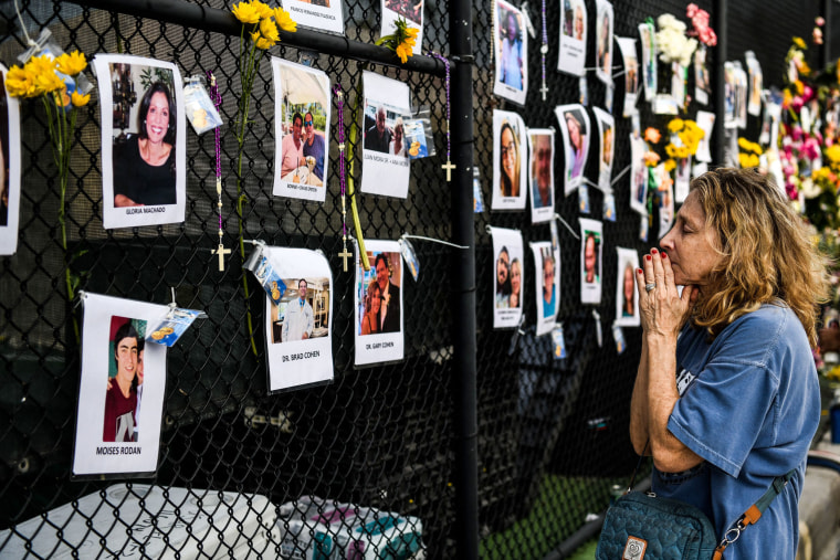 Image: A woman mourns at a makeshift memorial for possible victims of the building collapse in Surfside, Fla., on June 27, 2021.