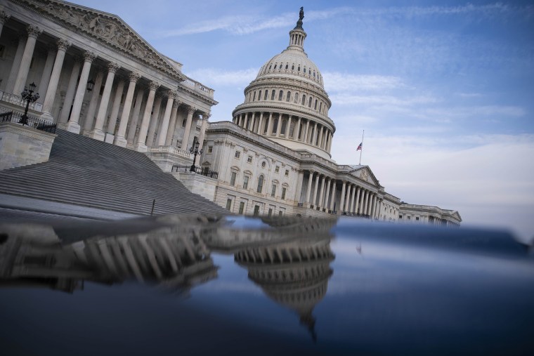 Image: The U.S. Capitol building is reflected on the hood of a car in Washington, DC.