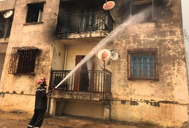 Image: A firefighter uses a water hose after a fire broke out at a building in Ain al-Hammam village in the Tizi Ouzou region, east of Algiers, Algeria