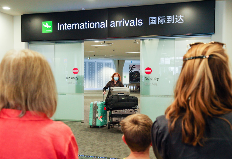Image: People wait to pick up their relatives from Australia at the arrival area of an airport in Christchurch, New Zealand