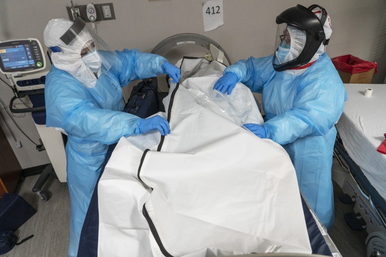 Medical staff members zip up a body bag containing a deceased patient in the Covid-19 intensive care unit at the United Memorial Medical Center on Dec. 6, 2020, in Houston, Texas.