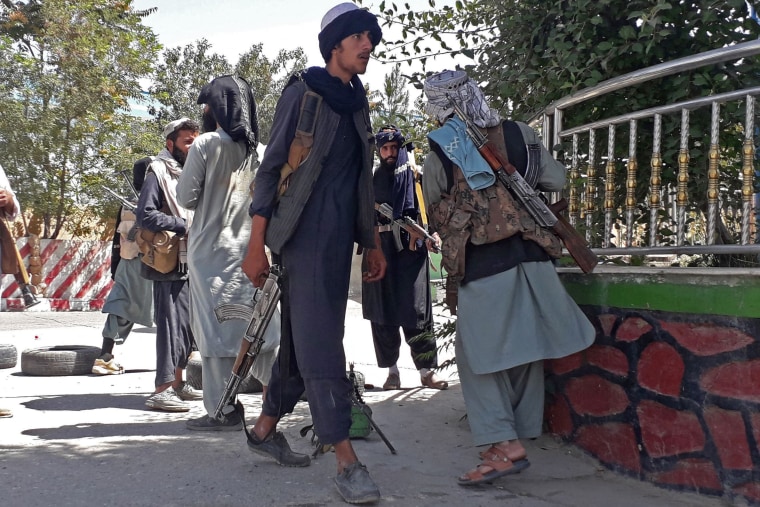 Taliban fighters stand along the roadside in Ghazni, Afghanistan, on Aug. 12, 2021.