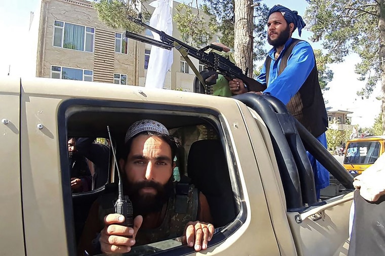 Image: Taliban fighters are pictured in a vehicle along the roadside in Herat, Afghanistan's third biggest city, after government forces pulled out the day before following weeks of being under siege,