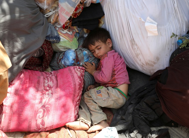 Image: Internally displaced families from northern provinces, who fled from their homes due the fighting between Taliban and Afghan security forces, take shelter in a public park in Kabul