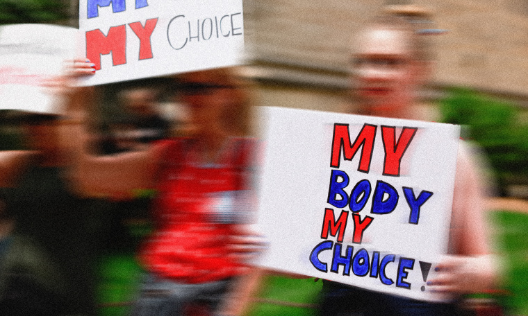 Image: A protestor holding a placard that reads,\"MY BODY MY CHOICE!\"