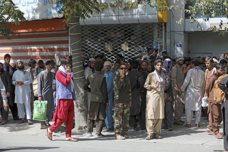 Afghans wait in long lines for hours to withdraw money in Kabul on Aug. 15, 2021.