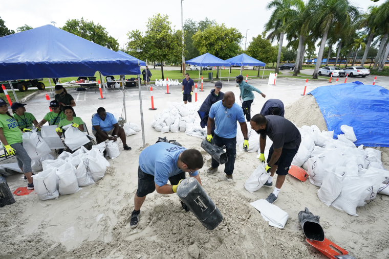 City workers fill sandbags at a drive-thru sandbag distribution event for residents ahead of the arrival of rains associated with tropical depression Fred on Aug. 13, 2021, at Grapeland Park in Miami.