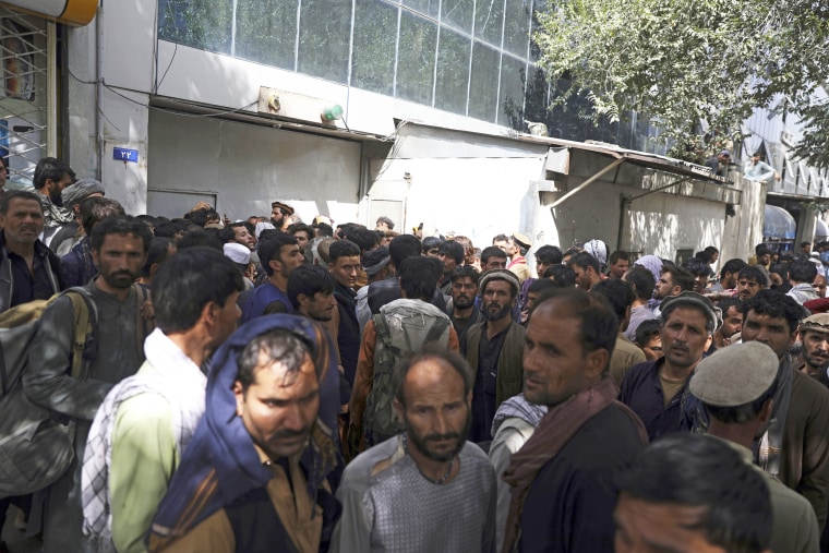 Afghans wait in long lines for hours to try to withdraw money in Kabul on Aug. 15, 2021.