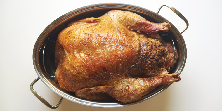 Overhead view of roasted turkey meat in container against white background