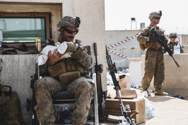 A US Marine assigned to the 24th Marine Expeditionary Unit calms an infant during an evacuation at Hamid Karzai International Airport in Kabul on August 20, 2021.