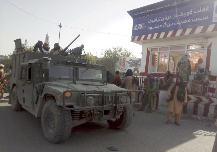 Image: Taliban fighters stand guard at a checkpoint in Kunduz city, northern Afghanistan