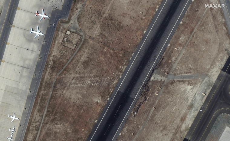 Security forces can be seen near one of the airport's main runways at Kabul's Hamid Karzai International Airport in Afghanistan, attempting to prevent crowds of people from moving toward other aircraft and from blocking flight operations on Aug. 16, 2021.