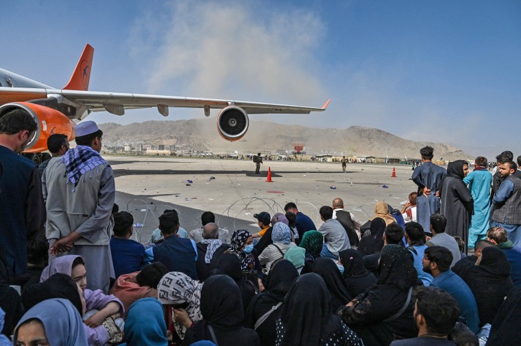 Afghan wait to leave the airport in Kabul on Aug. 16, 2021.