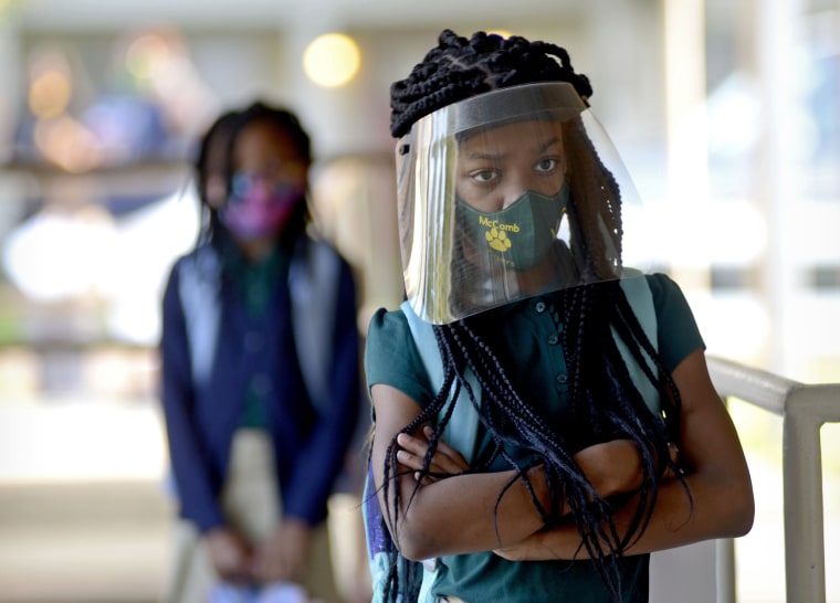 Victoria Dickens wears a mask and face shield as she waits for her class assignment at Summit Elementary School in Summit, Miss., on Aug. 5, 2021