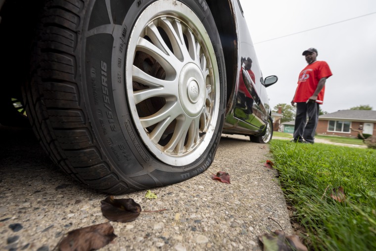 Eddie Hall Jr. inspects the tire damage to his son's car outside his Warren, Mich., home on Sept. 10, 2020.