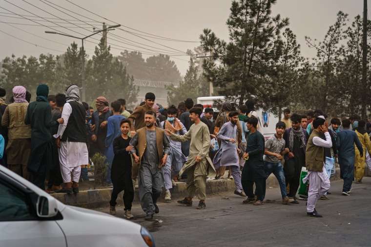 Image: Afghans run away from Taliban fighters outside the Kabul airport